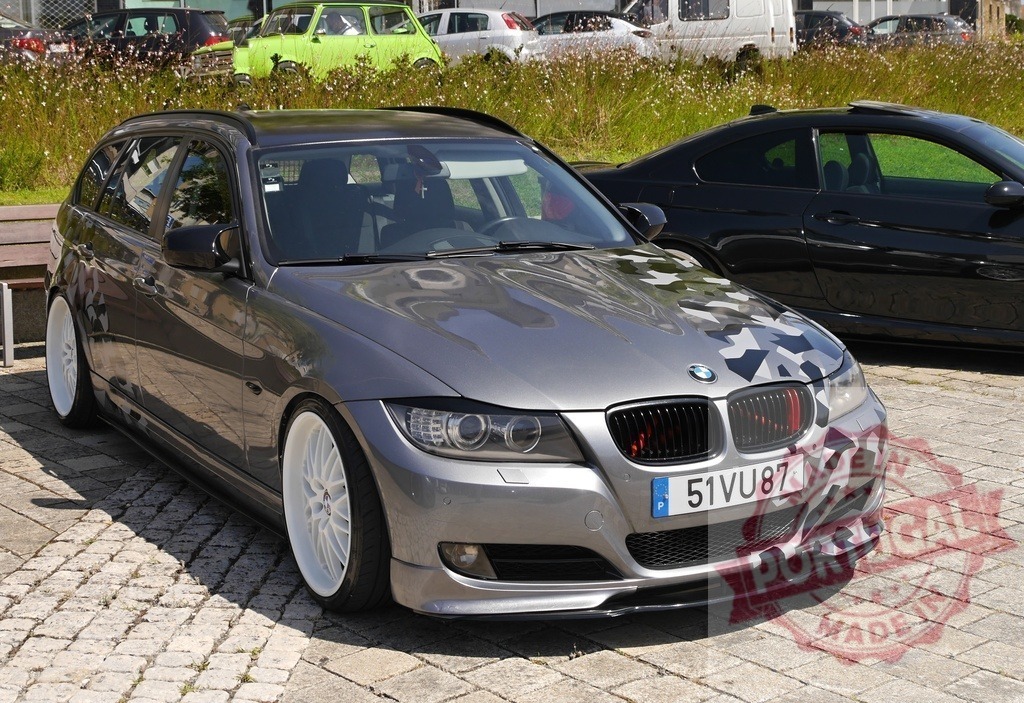 Custom BMW wagon with camouflage wrap and white wheels | Gray BMW station wagon with custom camouflage hood and white sport wheels parked on cobblestones - Realized with Pictrs.com