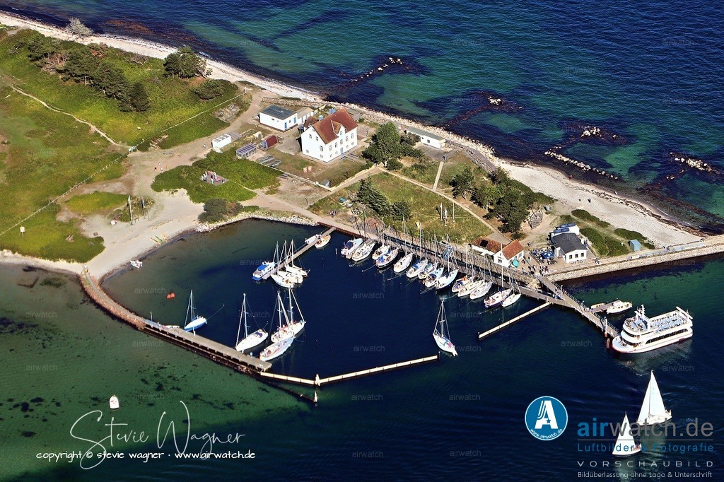Luftbild Schleimünde - Die „Giftbude“ in Schleimünde. | Die „Giftbude“ in Schleimünde ist ein Restaurant mit direktem Bezug zur Ostsee, bekannt für seine lockere, maritime Atmosphäre. Es bietet regionale Küche mit frischem Fisch und typischen norddeutschen Speisen, serviert in einem urigen, maritimen Ambiente. Die Gäste schätzen die einzigartige Lage und die entspannte Stimmung, oft in Verbindung mit einem schönen Ausblick. Bewertungen loben das freundliche Personal und die qualitativ hochwertigen Speisen, während gelegentlich Hinweise auf lange Wartezeiten bei starkem Betrieb erwähnt werden. Insgesamt genießt das Restaurant gute bis sehr gute Bewertungen und gilt als beliebter Treffpunkt in der Region.