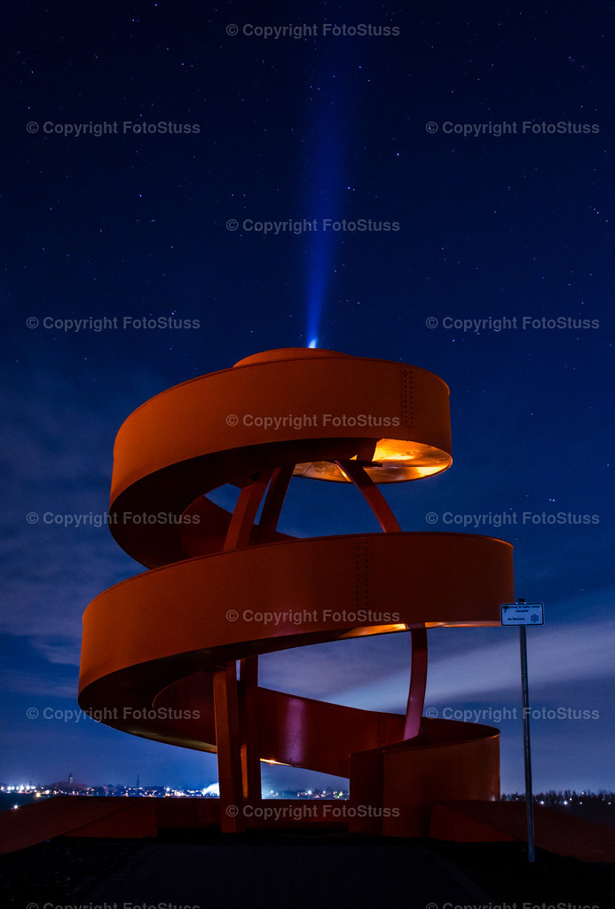 Haldenzeichen mit Lichtkegel | Das orangefarbene Haldenzeichen, gerne auch "Korkenzieher" genannt, mit einem Lichtkegel gen Himmel. - Realisiert mit Pictrs.com