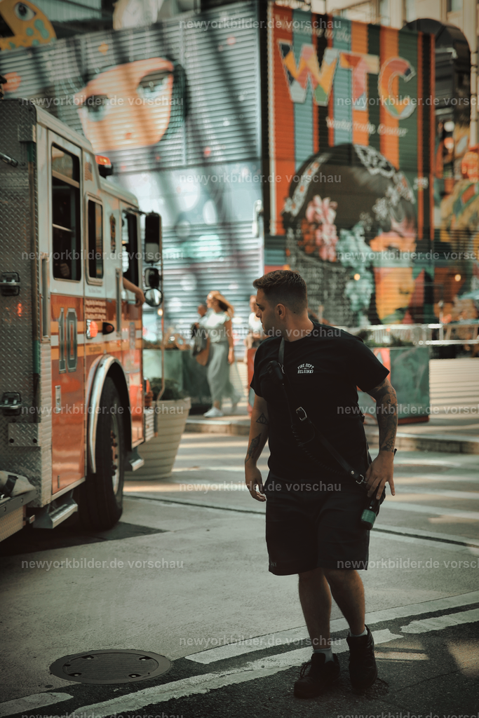 FDNY - Am Fuße von One World Trade Center und Oculus | Zwischen dem imposanten One World Trade Center und dem futuristischen Oculus entfaltet sich eine Szene, die Downtown Manhattan in seiner ganzen Vielfalt zeigt. Im Vordergrund steht der Leiterwagen der FDNY-Einheit Ladder 10 – ein Symbol für Sicherheit und Stärke, nur unweit von ihrem Hauptquartier am World Trade Center. Die glänzenden Linien des Trucks kontrastieren mit der modernen Architektur des Oculus, dem beliebten "WTC Beergarden" im Hintergrund und den Wolkenkratzern, die den Himmel durchbrechen.  Dieses Bild vereint Geschichte, Architektur und die Helden des Alltags in einer Komposition, die sowohl kraftvoll als auch atmosphärisch ist. Hier spürt man die Energie der Stadt und die Präsenz seiner Helden, die hier seit Jahrzehnten ein fester Bestandteil von New Yorks Identität sind.