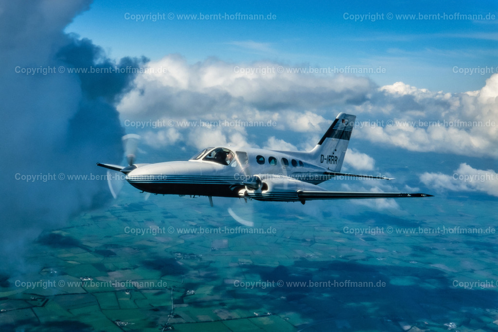 PLBDD_air2air_C421_06_90x60 | Luftbild. Zweimotoriges Geschäftsflugzeug ( Typ CESSNA 421 ) über den Wolken und zwischen Cumulus- Wolken im Luftraum zwischen Flensburg und Nordfriesland. ___ Das Foto ist eine Reproduktion von einem Farbdia. - Realisiert mit Pictrs.com