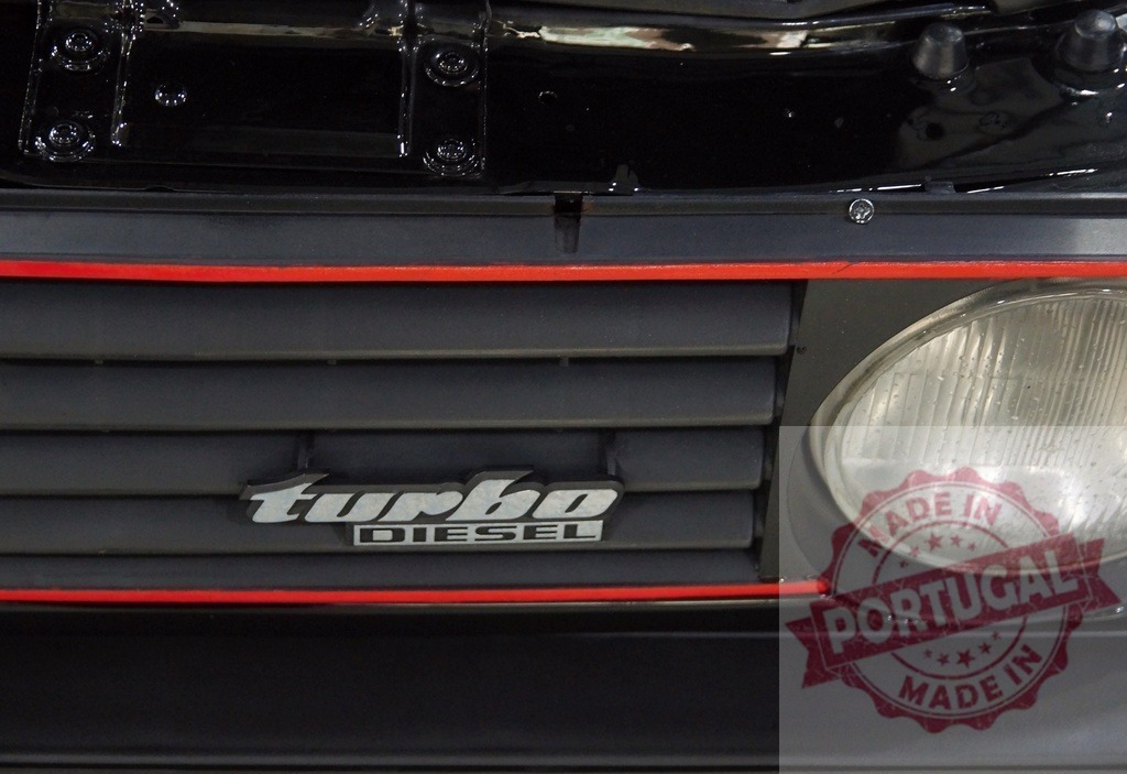 Volkswagen grille with turbo diesel emblem | Volkswagen car black front grille featuring a prominent turbo diesel emblem and red stripe - Realisiert mit Pictrs.com
