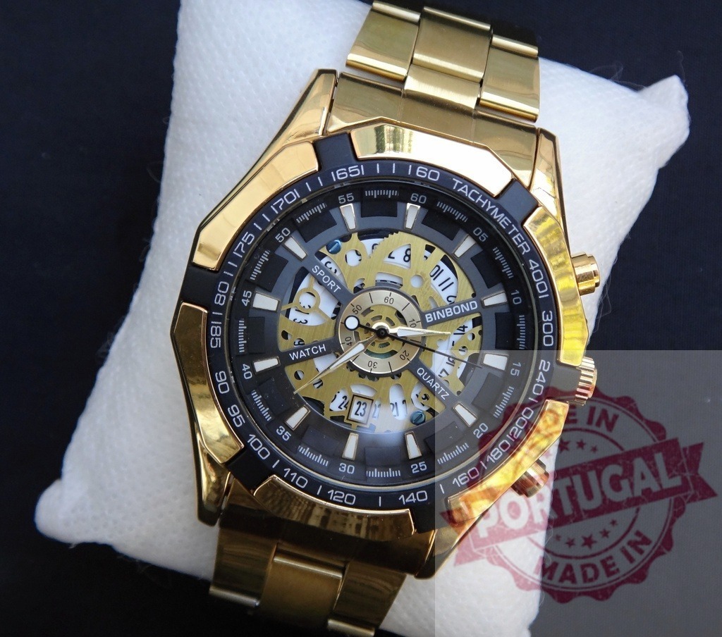 BINBOND gold skeleton dial chronograph watch displaying luxury and style | Gold BINBOND watch with a skeleton dial, chronograph, and metal strap on a white cushion - Realisiert mit Pictrs.com