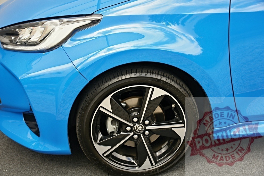 Toyota Yaris blue car front wheel and headlight | Toyota Yaris passenger car presenting front headlight, blue bodywork, and alloy wheel - Realized with Pictrs.com