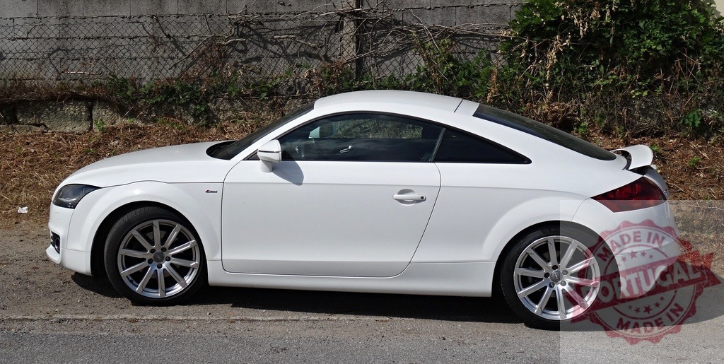 White Audi TT luxury sports coupe parked outdoors | White Audi TT luxury sports coupe parked on a roadside in profile against a wall - Realized with Pictrs.com