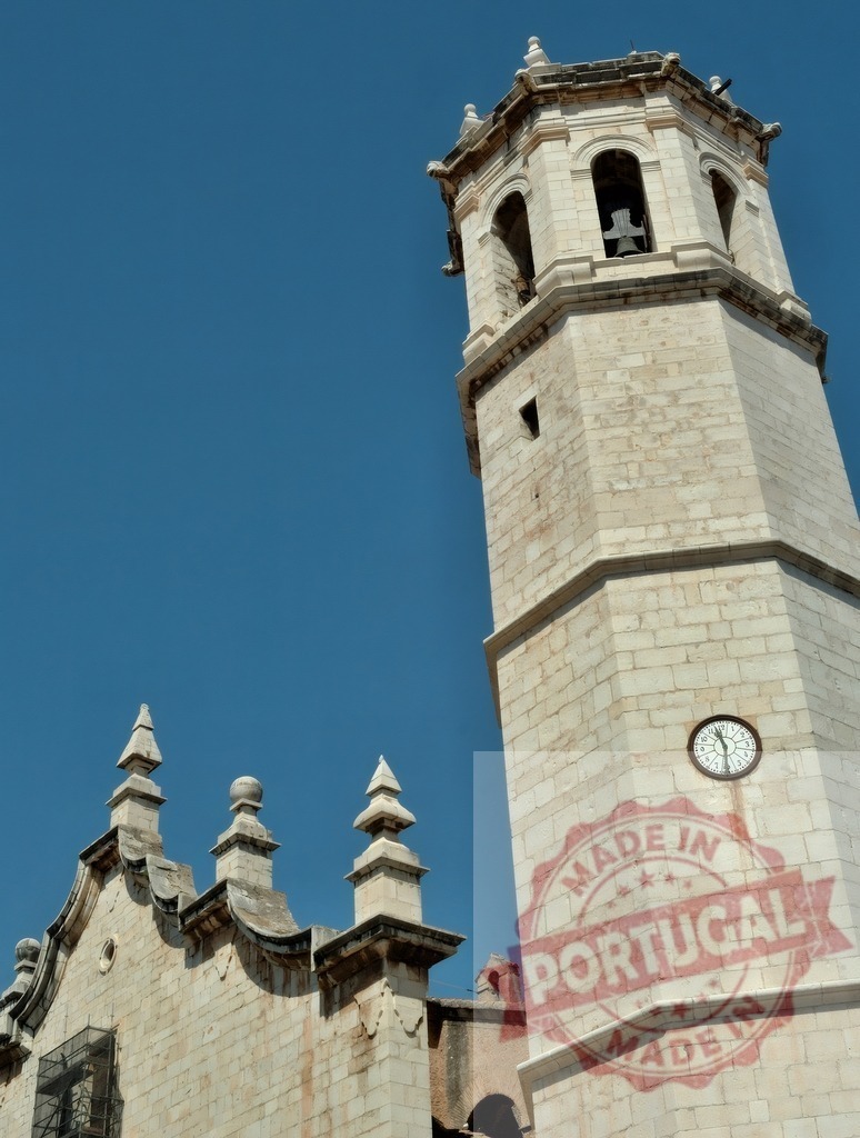 Stone bell tower with clock in a church | Stone bell tower reaching into a clear blue sky, featuring a bell and a clock face - Realisiert mit Pictrs.com