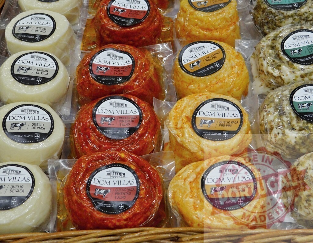 Dom Villas Portuguese cheeses in market display | Dom Villas cow's milk cheeses, packaged in various flavors, on display at a market - Realisiert mit Pictrs.com