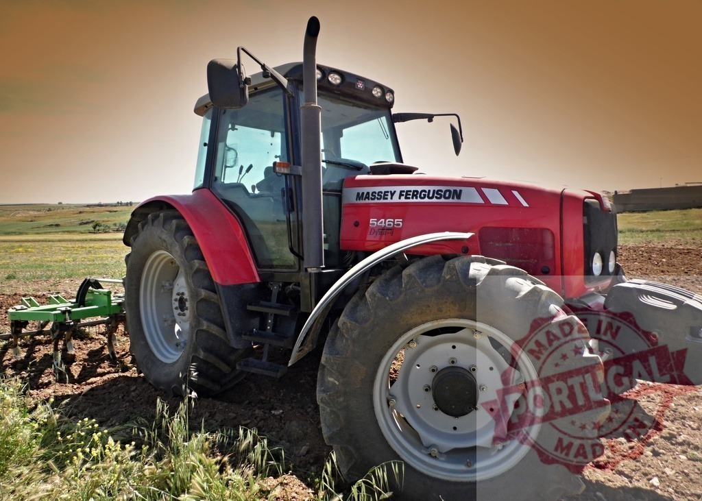 Massey Ferguson tractor working in a cultivated field | Red Massey Ferguson tractor cultivating a dry field under a clear sky - Realized with Pictrs.com