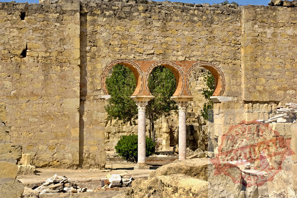 Madinat al-Zahra ancient ruins displaying horseshoe arches and columns. Spain - Cordoba | Madinat al-Zahra ruins showcases historical Moorish architecture under a clear sky - Realized with Pictrs.com