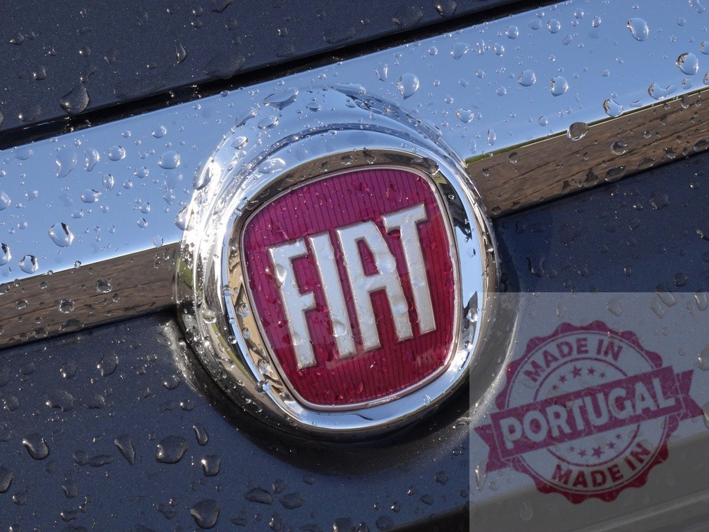 Fiat car emblem with raindrops on wet surface | Fiat logo on a car exterior is wet with many raindrops - Realized with Pictrs.com