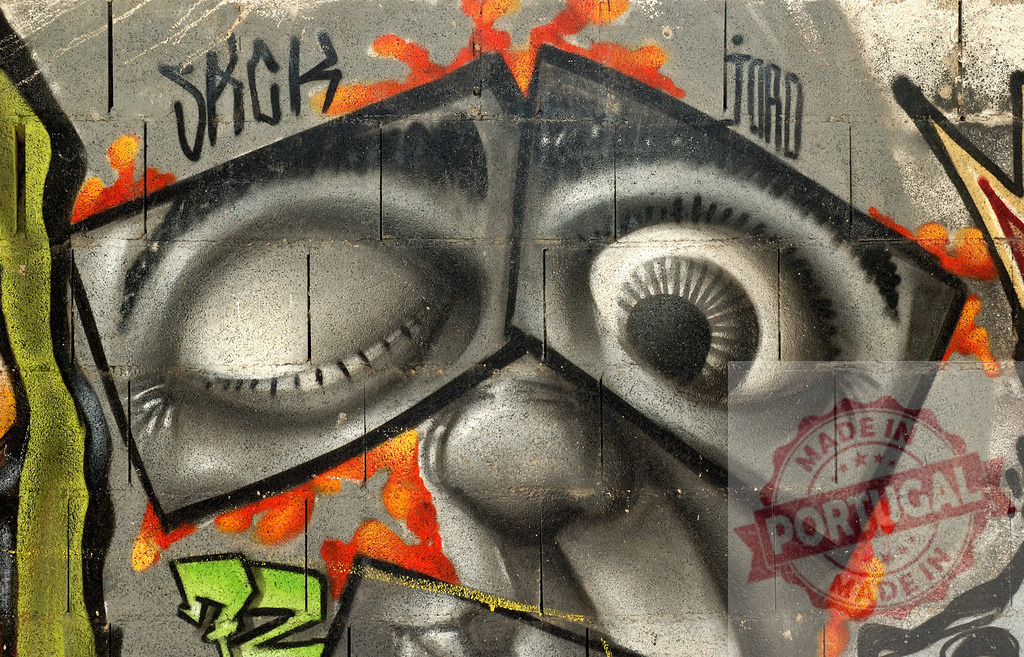 Graffiti face watching with one eye open and one eye almost closed | Graffiti face watching with one eye open and one eye almost closed, painted on a concrete wall - Realized with Pictrs.com