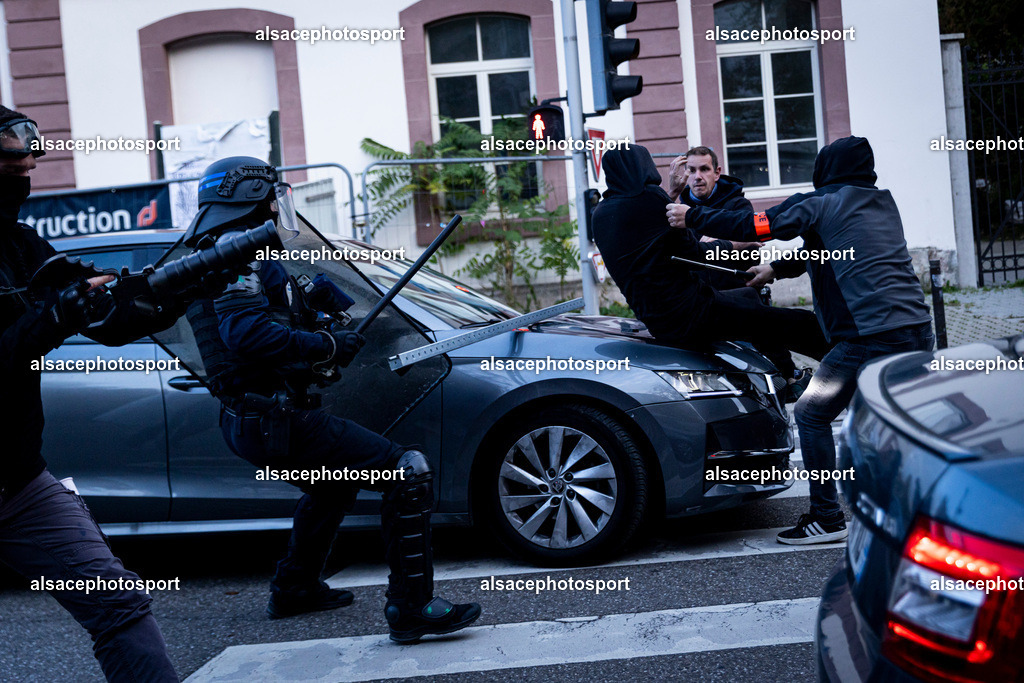 9L6A7387 | Strasbourg, France, 24 octobre 2026. Des manifestants affrontent les forces de l’ordre lors d’une mobilisation dans le centre-ville de Strasbourg. Des policiers interviennent pour disperser des groupes de manifestants, tandis que des gaz lacrymogènes sont utilisés. Des affrontements, des jets de projectiles et des dégradations sont observés dans plusieurs rues. Des barricades et des véhicules en feu témoignent de la tension qui règne en marge de la mobilisation. - Realisiert mit Pictrs.com