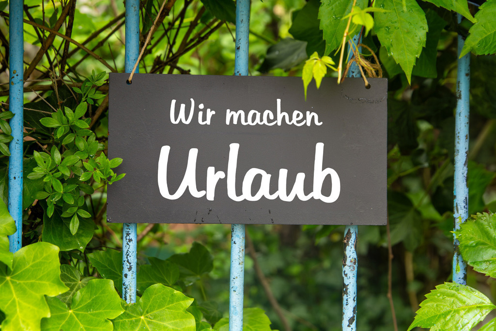 Symbolbild Betriebsferien/Urlaub: Schild am Garten mit der Aufschrift WIR MACHEN URLAUB | Symbolbild Betriebsferien/Urlaub: Schild am Garten mit der Aufschrift WIR MACHEN URLAUB - Realisiert mit Pictrs.com