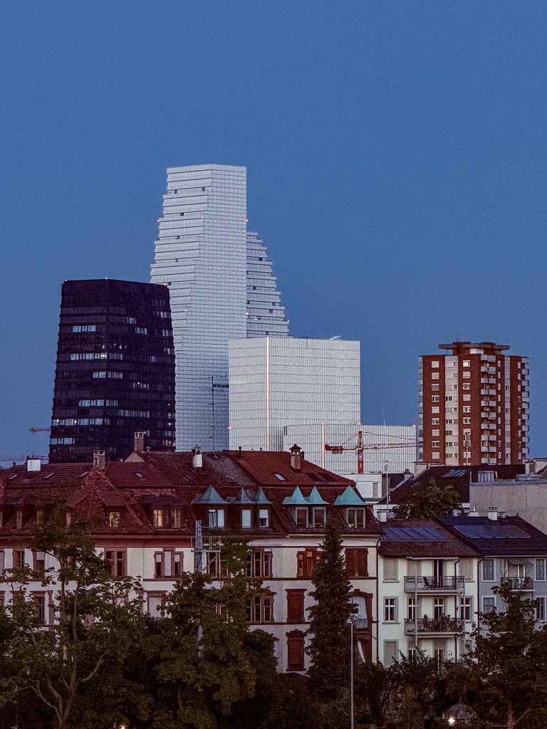 Wandbild Moderne Basel Skyline - Roche Towers am Tag | Dieses elegante Architektur-Wandbild zeigt die imponierende Skyline von Basel mit den markanten Roche-Türmen im hellen Tageslicht. Das harmonische Zusammenspiel aus zukunftsweisender, geometrischer Linienführung und einem von sanften Wolken durchzogenen Himmel bringt eine weite, weltoffene Atmosphäre in jeden Raum. Fotograf Robert Steinke fängt die urbane Eleganz und den modernen Herzschlag der Schweizer Metropole in gestochen scharfer Premium-Qualität ein. Ein absolutes Highlight für Design-Liebhaber, anspruchsvolle Büros oder das stilvolle Wohnzimmer. Erhältlich als hochwertiger Kunstdruck auf Leinwand, edlem Alu-Dibond oder unter brillantem Acrylglas für eine beeindruckende Galerie-Ästhetik. - Realisiert mit Pictrs.com