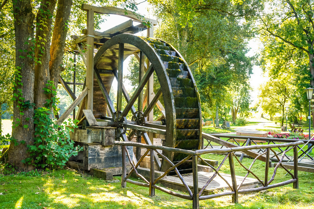 Salzrad - Bad Salzhausen | Mühlen stehen heute sinnbildlich für Romantik und Nostalgie. Während in unserer Region die Windmühlen weitestgehend verschwunden sind, zeugen in fast jedem Ort wasserbetriebene Holzräder von ihrer wichtigen Rolle im Alltag vergangener Generationen. Die Wassermühle ist mehr als nur ein Werkzeug. Sie ist ein Symbol für Beständigkeit und die leise, unaufhörliche Kraft der Natur, die buchstäblich Berge versetzen kann. - Realisiert mit Pictrs.com