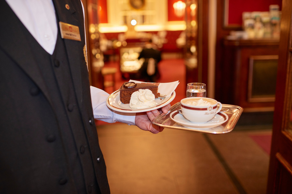 Café Sacher, Kellner serviert eine Sachertorte | Wien, Austria - August 22, 2017: Café Sacher, Kellner serviert eine Sachertorte. - Realisiert mit Pictrs.com