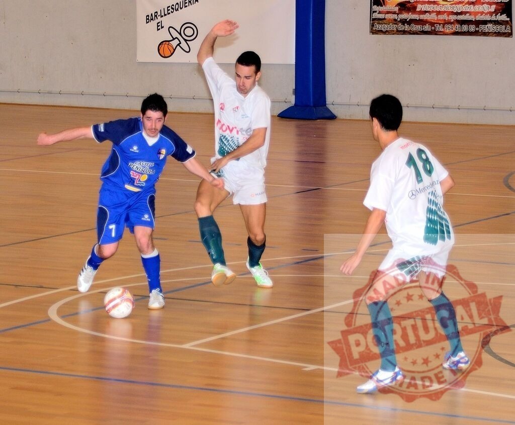 Futsal players competing during indoor soccer match | Three futsal players running and kicking ball during indoor soccer match - Realisiert mit Pictrs.com