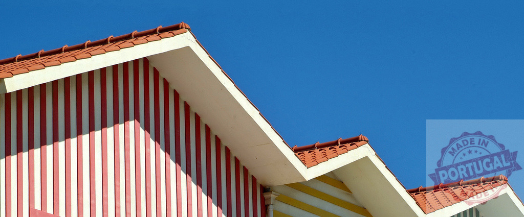 Costa Nova striped house architecture under blue sky | Traditional Costa Nova palheiro house featuring red and white vertical stripes - Realisiert mit Pictrs.com