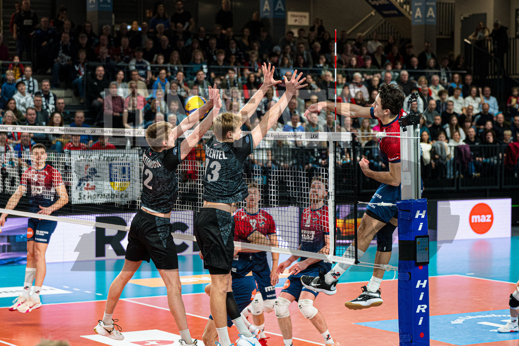 Volleyball I Herren I Saison 2025/2026 I Bundesliga I 8. Spieltag I SVG Lüneburg - FT 1844 Freiburg | Liam Kristjanson (12, FT 1844 Freiburg) und Jannik Brentel (13, FT 1844 Freiburg) im Block gegen Ethan Robert Champlin (20, SVG Lüneburg) - Realisiert mit Pictrs.com