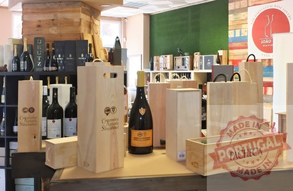 Wine bottles and wooden boxes displaying Portuguese selection | Assortment of wine bottles and branded wooden boxes on display in a liquor store - Realized with Pictrs.com