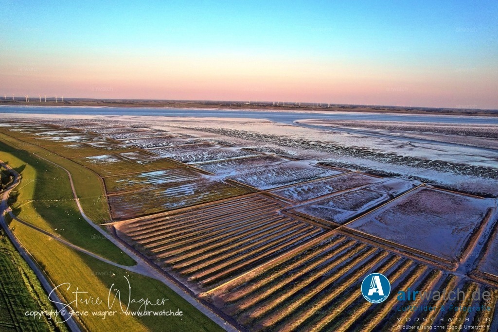 Luftbild Nordstrand, LangerDeich, Dreisprung, An de Wehl, Evensbüller Chaussee, Husumer Bucht | Luftbild Nordstrand, LangerDeich, Dreisprung, An de Wehl, Evensbüller Chaussee, Husumer Bucht - Die Landgewinnung auf Nordstrand ist Teil einer langen Tradition des Deichbaus und der Rekultivierung von Wattflächen. Bereits im Mittelalter begannen die Bewohner, Deiche zu errichten, um sich vor Sturmfluten zu schützen und neues Ackerland zu gewinnen. Im Laufe der Jahrhunderte wurden große Teile des Wattenmeers eingedeicht, wodurch die Halbinsel kontinuierlich vergrößert wurde.