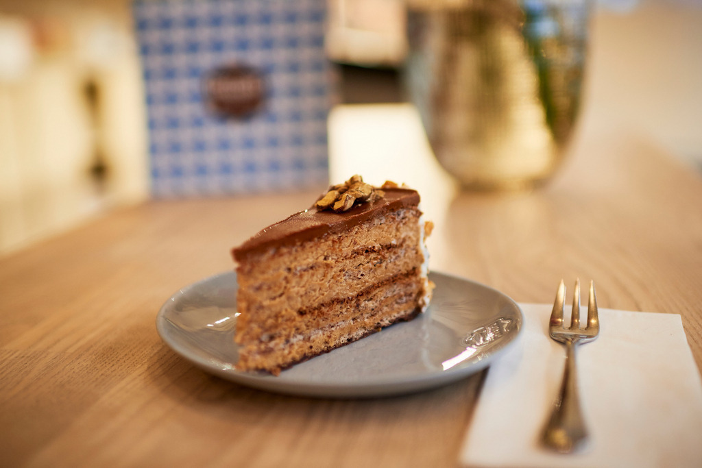 Gregors Konditorei | Wien, Austria - October 20, 2017: Gregors Konditorei, eine Japonaistorte steht auf dem Tisch, im Hintergrund eine Verpackung und eine Blumenvase. - Realisiert mit Pictrs.com