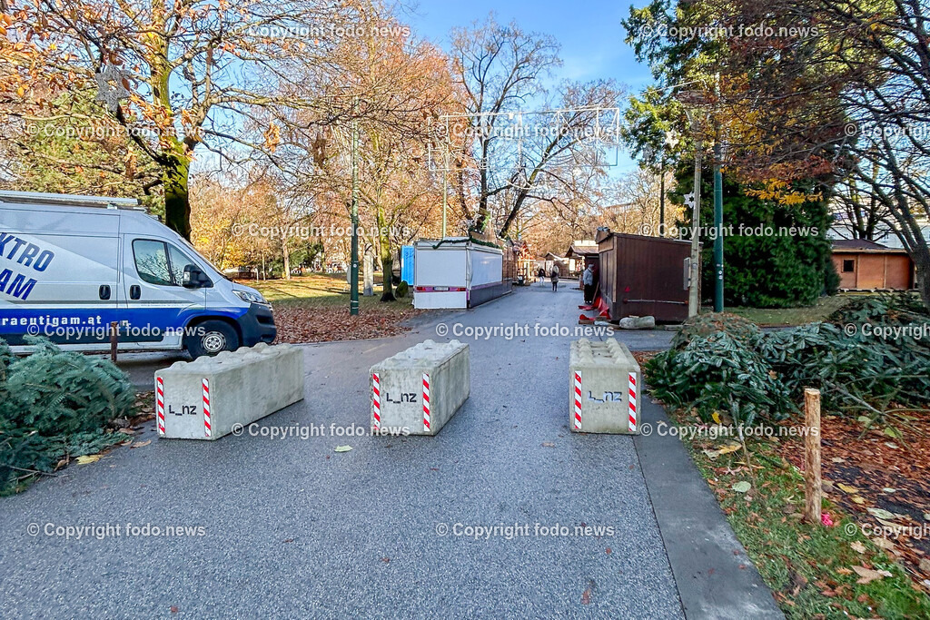 Linz_ Weihnachtsmarkt_ Terrorschutz_ 18.11.2025-17 | 18.11.2025, LINZ, AUT, Weihnachtsmarkt, im Bild Themenbild, Betonbarrieren, Betonblock, Terrorschutz, Volksgarten, Stadt, L_nz, Sicherheit, Fußgaengerzone, Weihnachtsmarkt, Huetten, Winter, Bauume ohne Laub, Absperrung, Verkehrsschutz, oeffentlicher Platz, Menschen, urban, Feature, Symbolbild