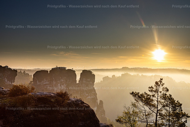Sonnenaufgang über der Sächsischen Schweiz | Stimmungsvoller Sonnenaufgang über den Felsen und Wäldern der Sächsischen Schweiz. Das warme Licht, der feine Dunst und die markanten Felsformationen erzeugen eine ruhige, majestätische Landschaftsstimmung. - Realisiert mit Pictrs.com