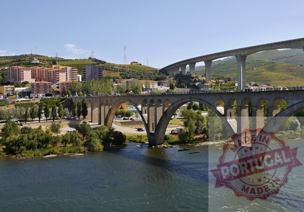 Peso da Régua bridges crossing Douro river in Portugal | Two bridges spanning Douro river with Peso da Régua cityscape and terraced vineyards - Realized with Pictrs.com