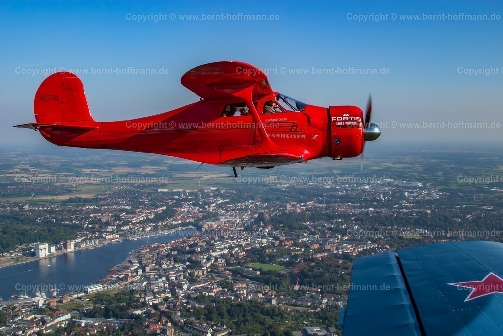 PLB_Staggerwing_118_1815mod_105x70 | Luftbild. Historischer Doppeldecker Typ Beechcraft Staggerwing über Flensburg. Die blaue Tragfläche gehört zum Fotoflugzeug (Typ YAK-52) - Realisiert mit Pictrs.com