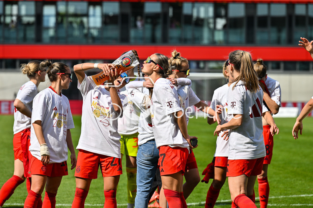 FC Bayern München - SC Freiburg | Die Spielerinnen des FC Bayern feiern die Meisterschaft nach dem Heimsieg gegen den SC Freiburg / Frauen Bundesliga: FC Bayern Muenchen - SC Freiburg, FC Bayern Campus am 27.04.2025 / Arianna CARUSO (FC Bayern Muenchen Frauen 27) gibt Klara BUEHL (FCB #17) einen Schluck auf dem Paulaner Bierkrug / Bierglas