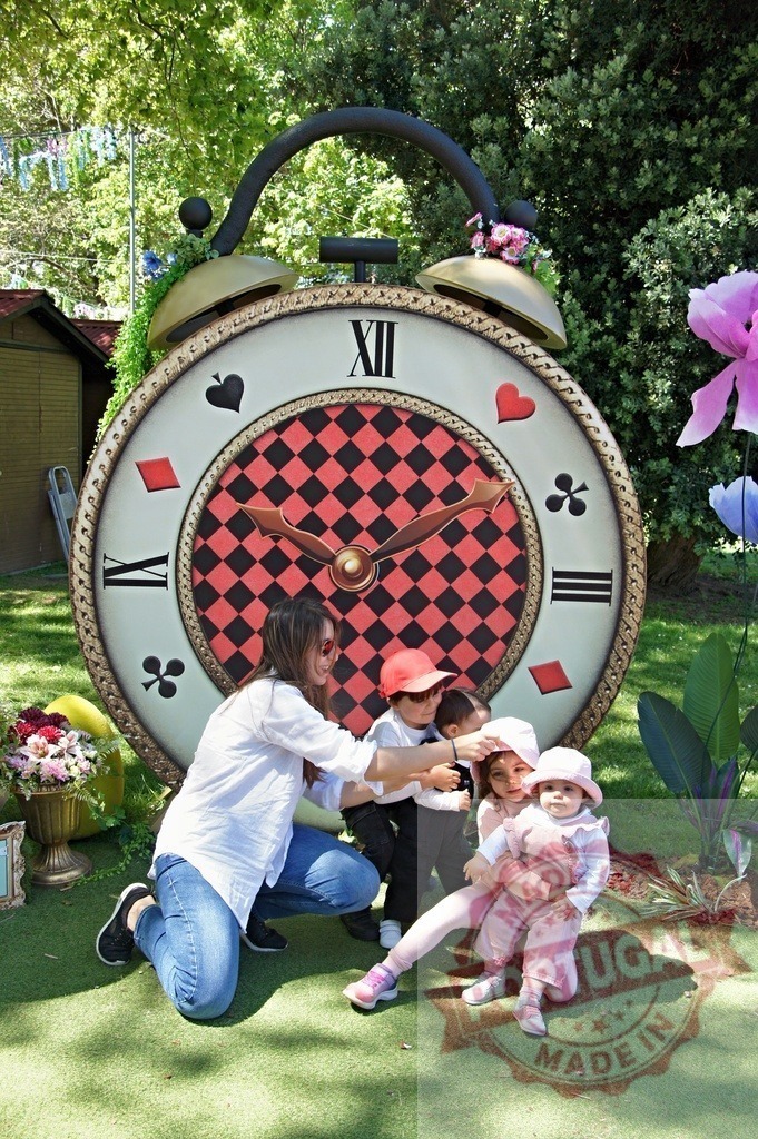 Family playing at Wonderland themed giant clock | Family with small children enjoying a whimsical garden party with oversized props - Realized with Pictrs.com