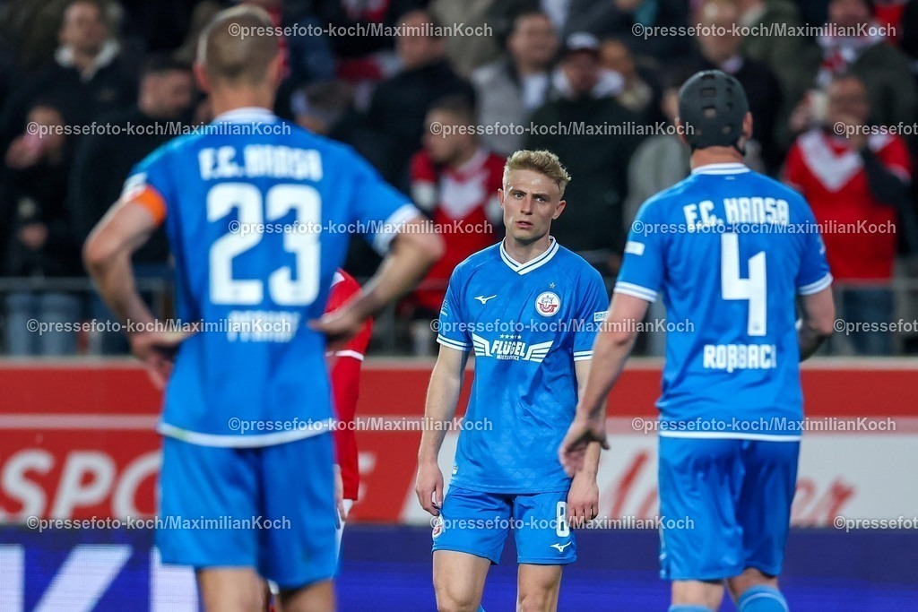 RWE06042501096 | 2025.04.06, Fußball, 3.Liga, Rot-Weiss Essen - FC Hansa Rostock, Stadion Hafenstraße, Saison 2024 2025: Enttäuschung nach der 1:2 Niederlage - Franz Pfanne (FC Hansa Rostock #23) Cedric Harenbrock (FC Hansa Rostock #08) Damian Roßbach (FC Hansa Rostock #04) stehen enttäuscht auf dem SpielfeldDFB regulations prohibit any use of photographs as image sequences and or quasi-video.