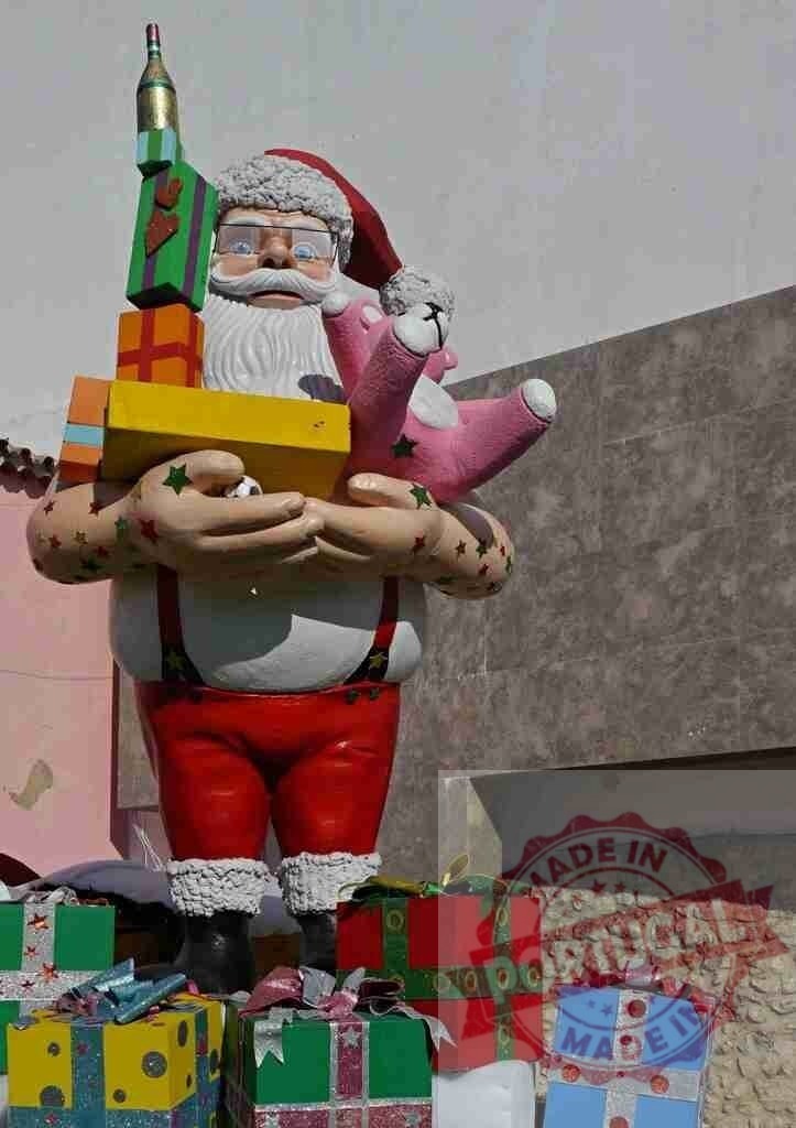 Quirky Santa Claus statue holding gifts and a pink teddy bear | Statue of Santa Claus with tattoos holding Christmas gifts and a pink teddy bear - Realisiert mit Pictrs.com