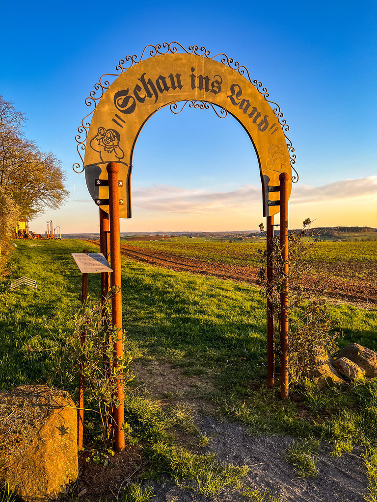Tor der Einsicht - Wenings | Oberhalb von Wenings auf dem Weg nach Gedern liegt ein liebevoll gestalteter Aussichtspunkt. Mit einem Ensemble der Materialen Holz, Stein und Metall wird die Vielfältigkeit der Region in Szene gesetzt. Bereits die kleinsten Einwohner zieht es während eines Naturtages des Kindergartens zur Hügelkuppel. Für Groß und Klein eröffnet sich eine Welt des Ausprobierens und Erlebens. So wird Natur greifbar. - Realisiert mit Pictrs.com