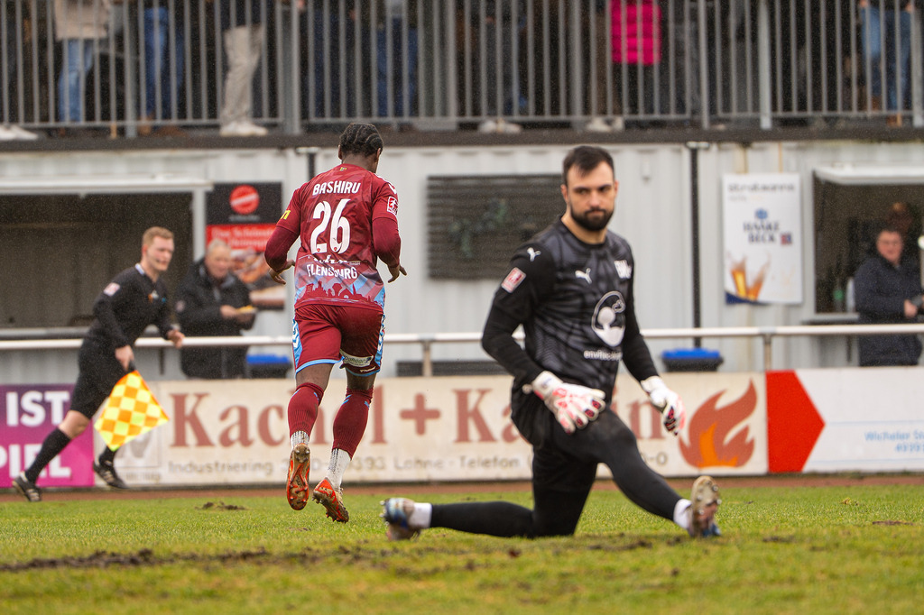 Fußball I Herren I Saison 2025-2026 I Regionalliga Nord I 23. Spieltag I TuS Blau-Weiß Lohne - SC Weiche Flensburg 08 I 0041 | Ibrahim Bashiru Ali (26, SC Weiche Flensburg 08) vorbei an Marko Dedovic (1, TuS BW Lohne) - Realisiert mit Pictrs.com