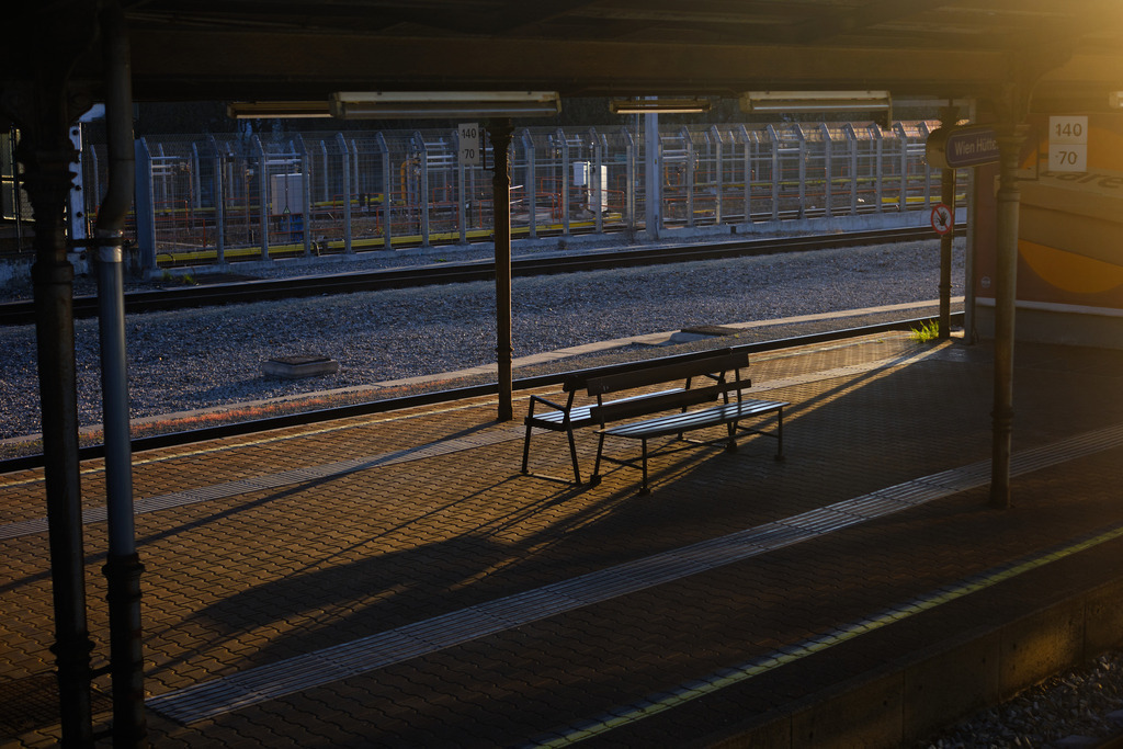 Bahnsteig mit Sitzbank im Abendlicht | Austria - April 03, 2025: Bahnsteig mit Sitzbank im Abendlicht. - Realisiert mit Pictrs.com