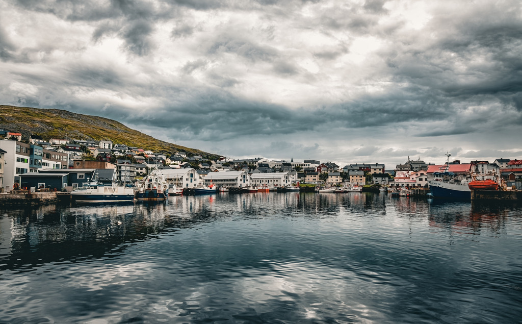 Der Hafen von Honningsvåg, viele Boote und dramatischer Himmel | Die Abbildung zeigt den Hafen von Honningsvåg, einer Stadt in der Gemeinde Nordkapp im Norden Norwegens. Honningsvåg liegt auf der Insel Magerøya und ist bekannt für seine spektakuläre Landschaft. Die Stadt ist ein wichtiger Anlaufpunkt für Kreuzfahrtschiffe und der Ausgangspunkt für Reisen zum Nordkap.  - Realisiert mit Pictrs.com