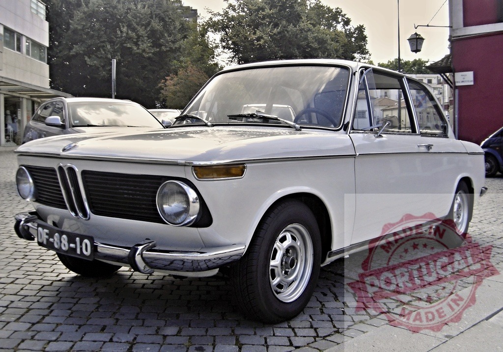 White BMW 1602 parking on a cobblestone street | Classic white BMW 1602 parked on a cobblestone street in an urban environment - Realized with Pictrs.com
