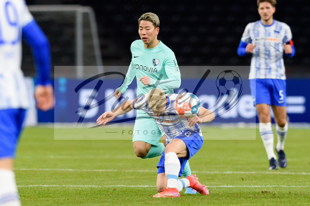 HERFUE20220204_007 | Fussball, Herren: Takuma Asano (VfL Bochum) und Santiago Ascacibar (Hertha BSC) im Zweikampf bei dem Spiel der 1. Bundesliga zwischen Hertha BSC und VfL Bochum im Olypiastadion am 04.02.2022 in Berlin, Deutschland.DFB / DFL REGULATIONS PROHIBIT ANY USE OF PHOTOGRAPHS AS IMAGE SEQUENCES AND/OR QUASI-VIDEO. - Realisiert mit Pictrs.com