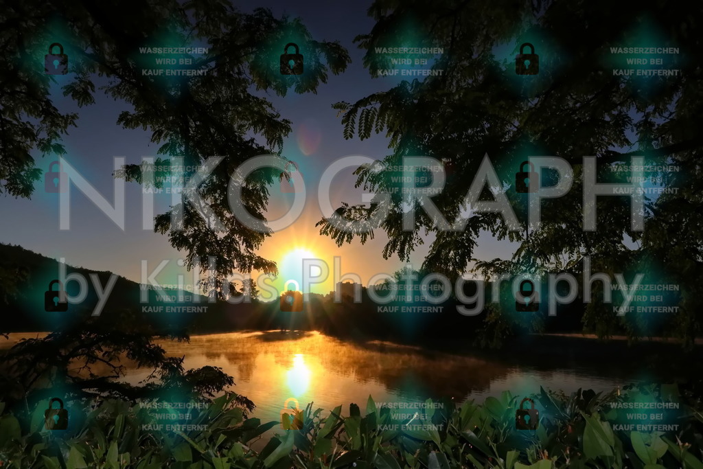 Sonnenaufgang am Seilersee | Die aufgehende Sonne spiegelt sich in der Oberfläche der Callerbachtalsperre (Seilersee) und lässt die Wasseroberfläche golden schimmern.