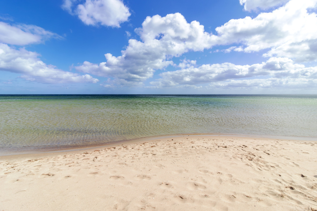 Wandbild: Sand und Wellen – Küstenidylle pur | Sanfte Farben und eine beruhigende Küstenlandschaft – dieses Wandbild vermittelt die entspannte Atmosphäre eines Sommertages am Weidefelder Strand. Die ruhige Bildkomposition mit dem weichen Sand und dem klaren Wasser schafft eine offene und harmonische Raumwirkung. Ideal für Wartezimmer, Behandlungsräume oder Empfangsbereiche, um eine stressfreie und wohltuende Umgebung zu gestalten. - Realisiert mit Pictrs.com