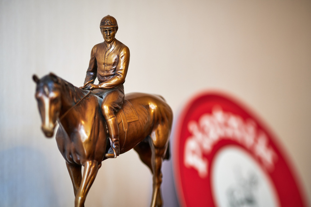 Piatnik Jockey Bronze Figur im Büro | Wien, Austria - April 07, 2021: Piatnik &amp; Söhne Spieleverlag; die Piatnik Jockey Bronze Figur im Büro. - Realisiert mit Pictrs.com