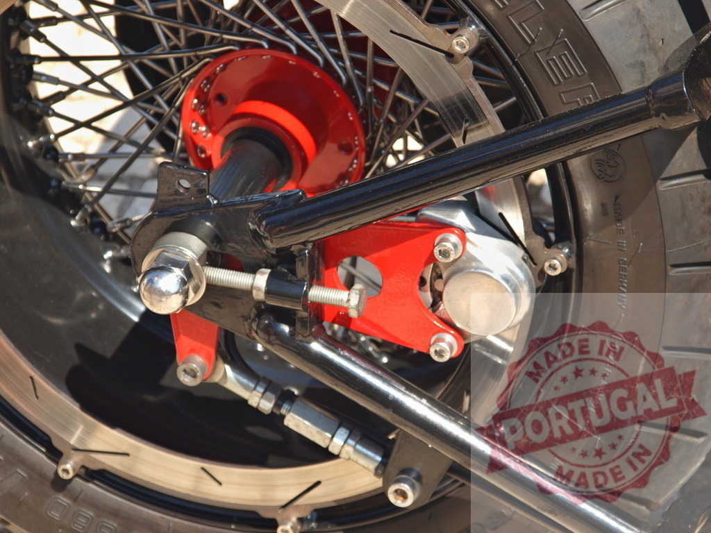 Custom motorcycle rear wheel mechanical detail with red hub | Close up view of a custom motorcycle's intricate rear wheel, showing the spoke design, red hub, and braking system - Realized with Pictrs.com