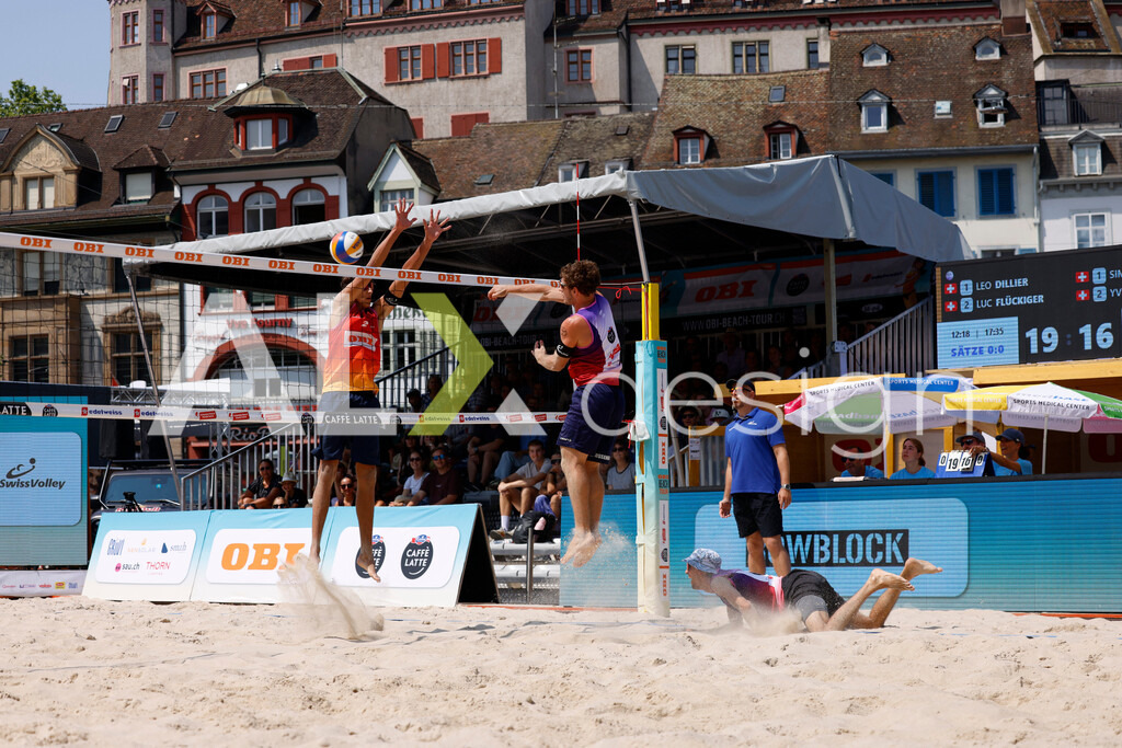 Obi BeachTour 2026 - Basel | BASEL, SWITZERLAND - JULY 19: YVES HAUSSENER (SUI) attack / spike against LUC EMANUEL FLÜCKIGER (SUI) block during the Obi BeachTour 2026 match between DILLIER / FLÜCKIGER (SUI) and HAGENBUCH / HAUSSENER (SUI) at Barfüsserplatz on July 19, 2026 in Basel, Switzerland. - Realisiert mit Pictrs.com
