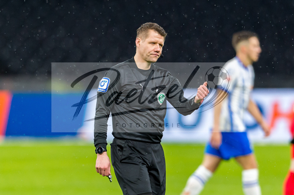 BSCRBL20220220_054 | Fussball, Herren: Schiedsrichter Patrick Ittrich gestikuliert, Gestik bei dem Spiel der 1. Bundesliga zwischen Hertha BSC und RB Leipzig im Olypiastadion am 20.02.2022 in Berlin, Deutschland.DFB / DFL REGULATIONS PROHIBIT ANY USE OF PHOTOGRAPHS AS IMAGE SEQUENCES AND/OR QUASI-VIDEO. - Realisiert mit Pictrs.com