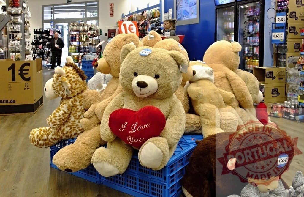 Stuffed animals and teddy bears for sale in shop | Large plush teddy bears and a giraffe toy on display, with a I Love You heart - Realisiert mit Pictrs.com