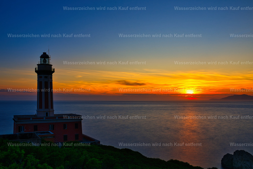Capri - Blick zum Faro di Punta Carena mit Leuchtturm im Sonnenuntergang | Capri ist eine traumhafte Insel im Golf von Neapel, bekannt für türkisblaues Meer, beeindruckende Felsklippen, mediterrane Landschaften und die berühmten Faraglioni. - Realisiert mit Pictrs.com