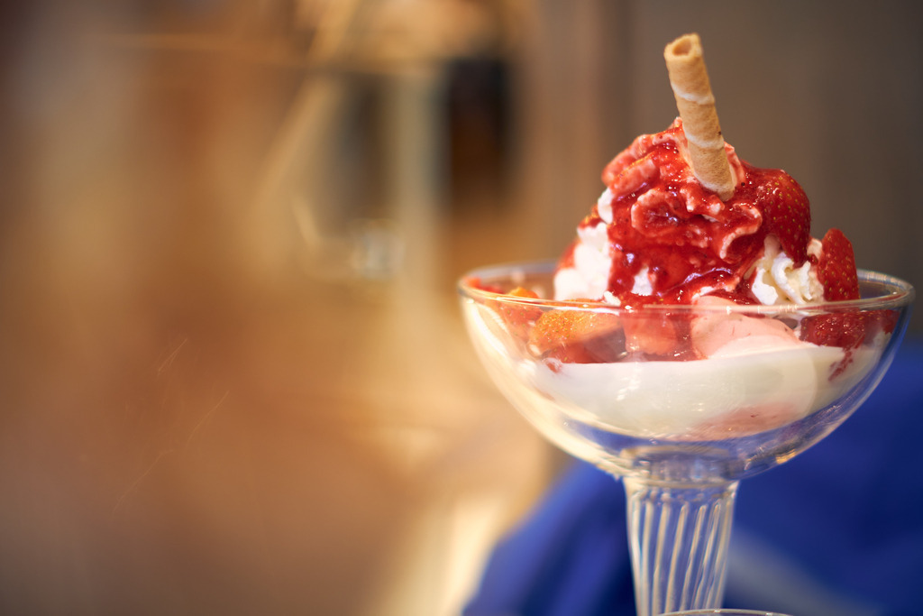 Nahaufnahme eines Eisbechers mit Hohlhippe | Wien, Austria - December 31, 2021: Nahaufnahme eines Eisbechers mit Sahne, Erdbeeren und einer Hohlhippe. - Realisiert mit Pictrs.com