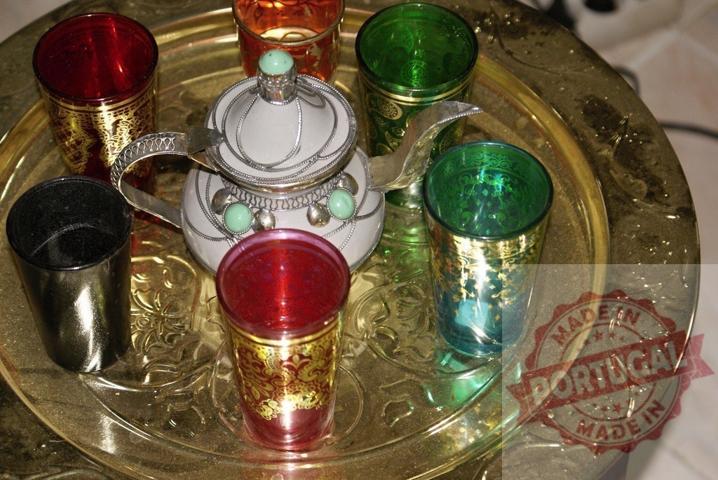 Moroccan tea service with traditional teapot and colored glasses on tray | Traditional Moroccan tea set with decorated teapot and ornate glasses arranged on a brass tray - Realized with Pictrs.com